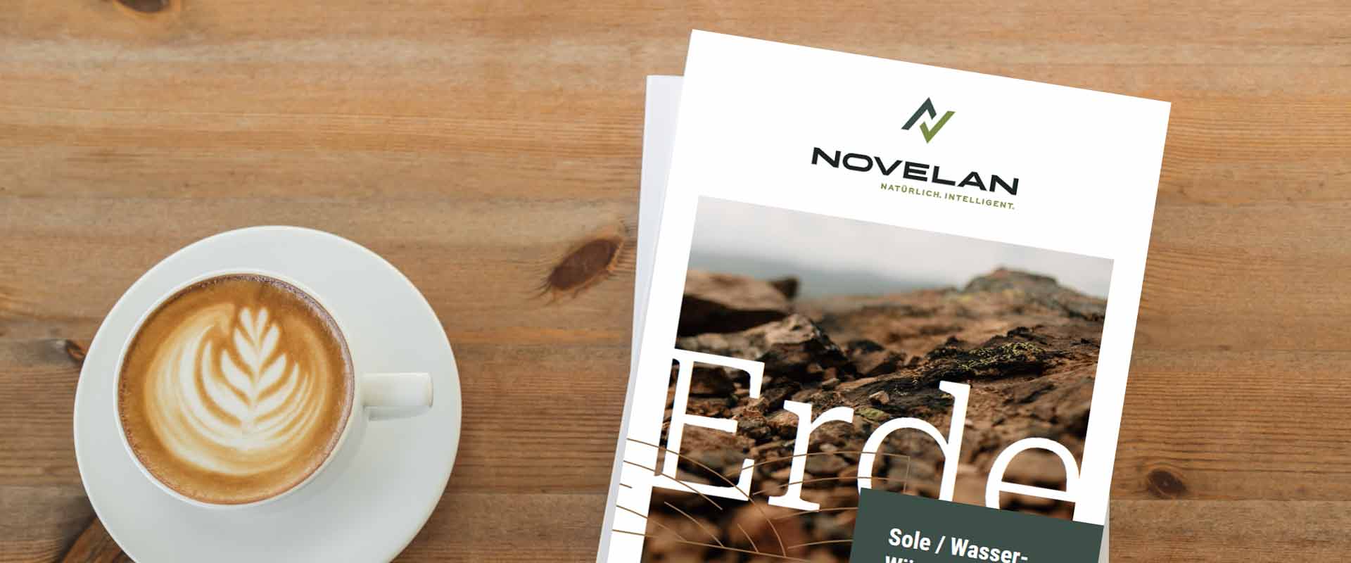 Two brochures lie next to a cup of coffee on a wooden table. On the front page, there is the NOVELAN logo in the upper middle with a picture of soil underneath on which it says, “soil”.