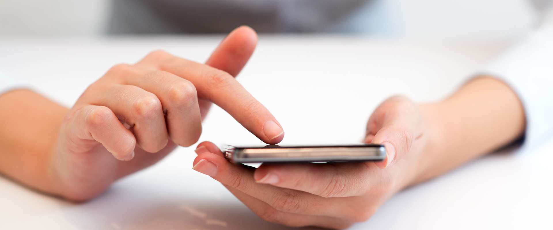 Frau hält Handy in der Hand und tippt 